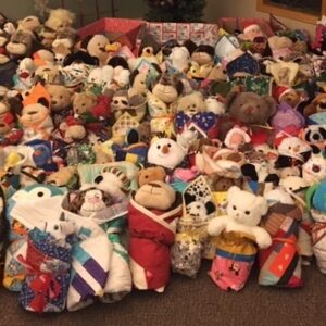 Photo showing 200+ stuffed toys wrapped in individual quilts
