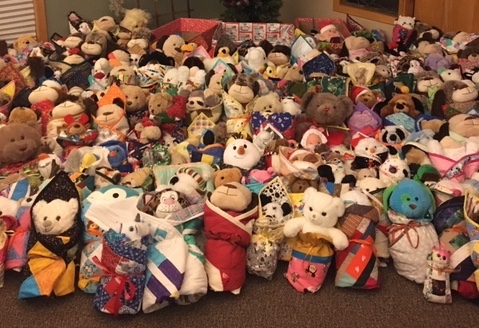 Photo showing 200+ stuffed toys wrapped in individual quilts